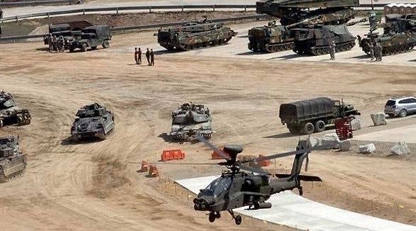مروحية عسكرية أمريكية وآليات حربية في معسكر التاجي العراقي (أرشيف)