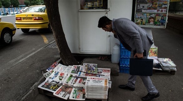 رجل يعاين مجموعة من الصحف والمجلات في أحد شوارع طهران (أرشيف)