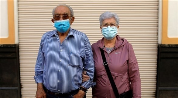 مسنان يرتديان كمامات (رويترز)