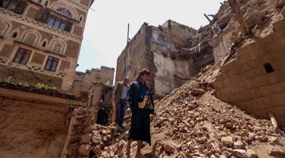 يمنيون يقفون على ركام بيوت دمرتها السيول في صنعاء (أ ف ب)