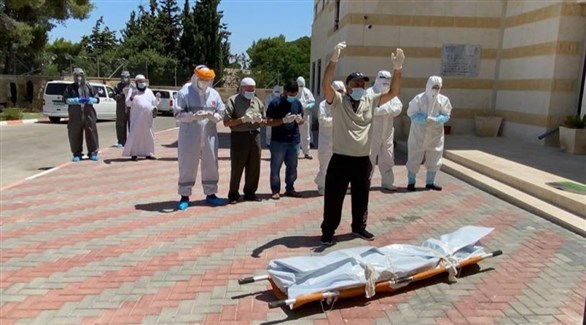 فلسطينيون يؤيدون صلاة الجنازة على أحد ضحايا كورونا في الضفة الغربية (أرشيف)