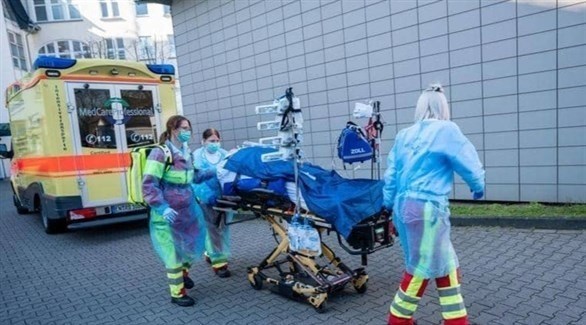 نقل مريض بفيروس كورونا من سيارة إسعاف لإحدى المستشفيات في ألمانيا (أرشيف)