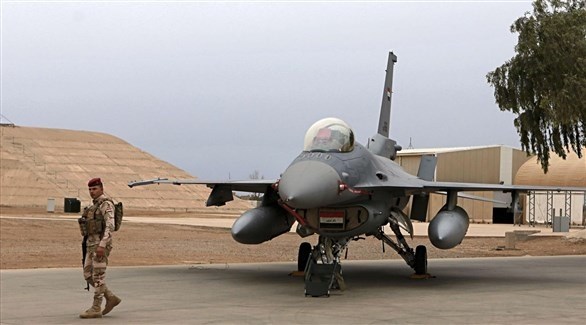 طائرة عسكرية أمامها جندي عراقي في قاعدة بلد الجوية (أرشيف)
