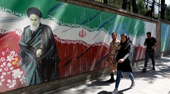 أشخاص يمرون بجانب جدارية وسط طهران (أرشيف)