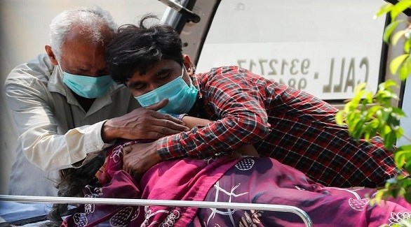 هندي يحضن ابنه وزوجته التي قتلها الوباء في مستشفى (أرشيف)