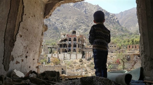 طفل ينظر إلى الخارج من أحد المباني المهدمة في اليمن (أرشيف)