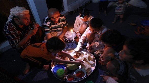 عائلة يمنية تتناول عشاءها على ضوء الشموع (أرشيف)