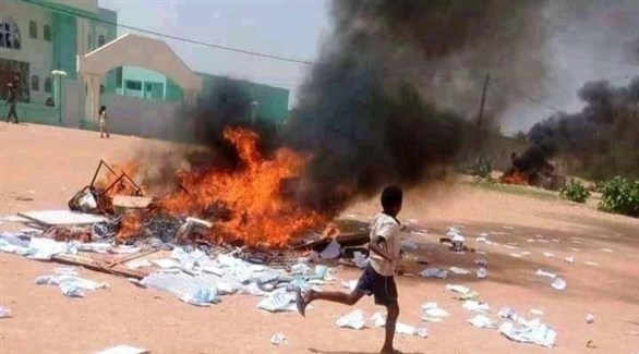 طفل أمام وثائق محترقة لشركة صوملك الموريتانية في احتجاجات أمس (تويتر)