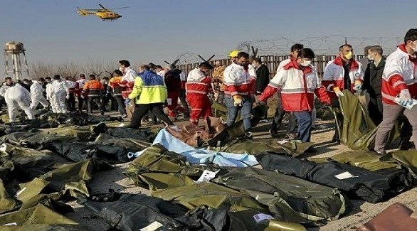 مسعفون إيرانيون إلى جانب جثث ضحايا الطائرة المنكوبة (أرشيف)