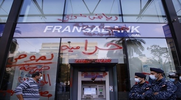 لبنانيون أمام صراف آلي لبنك فرنسابنك اللبناني بعد إغلاقه بالشمع الأحمر (تويتر)