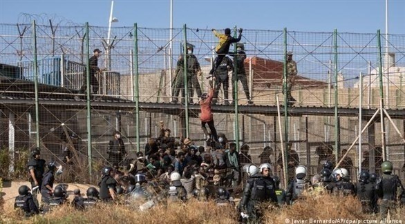 مهاجرون يتسلقون سياجاً بين المغرب ومليلية (أرشيف)