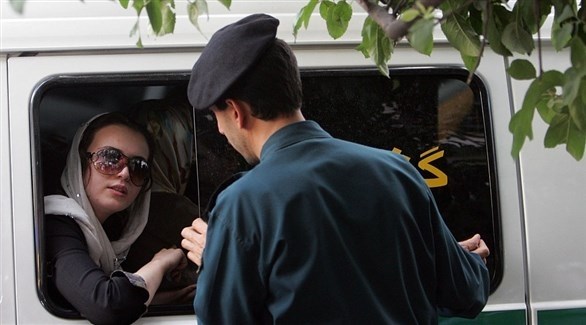 شرطي إيراني يدقق في التزام نساء الحجاب في باص.(أف ب)